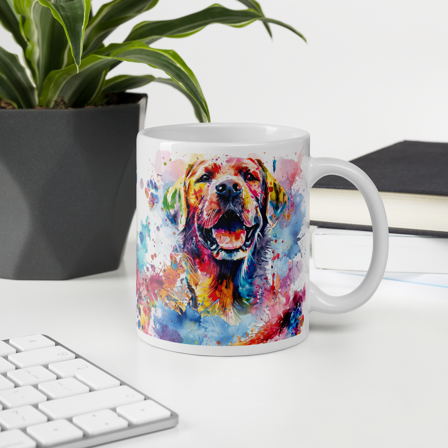 Doggone Proud Lab 11 oz Mug. A fun mug with a happy Labrador Retriever dog surrounded by colorful watercolor splashes, clouds, and paws. Mug is on a white desk with a plant book and keyboard. Great give for any dog lover or paw-rent.