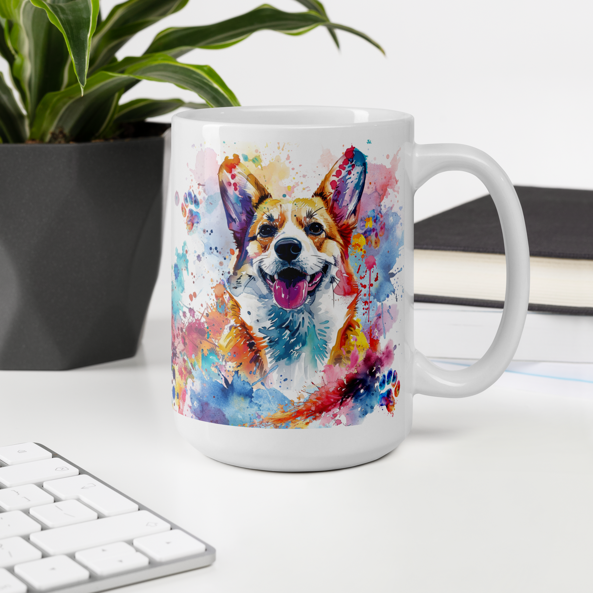 Doggone Proud Corgi 15 oz Mug. A fun mug with a happy Corgi dog surrounded by watercolor splashes, clouds, and paws. Mug is on a white desk with a plant book and keyboard. Great give for any dog lover or paw-rent.