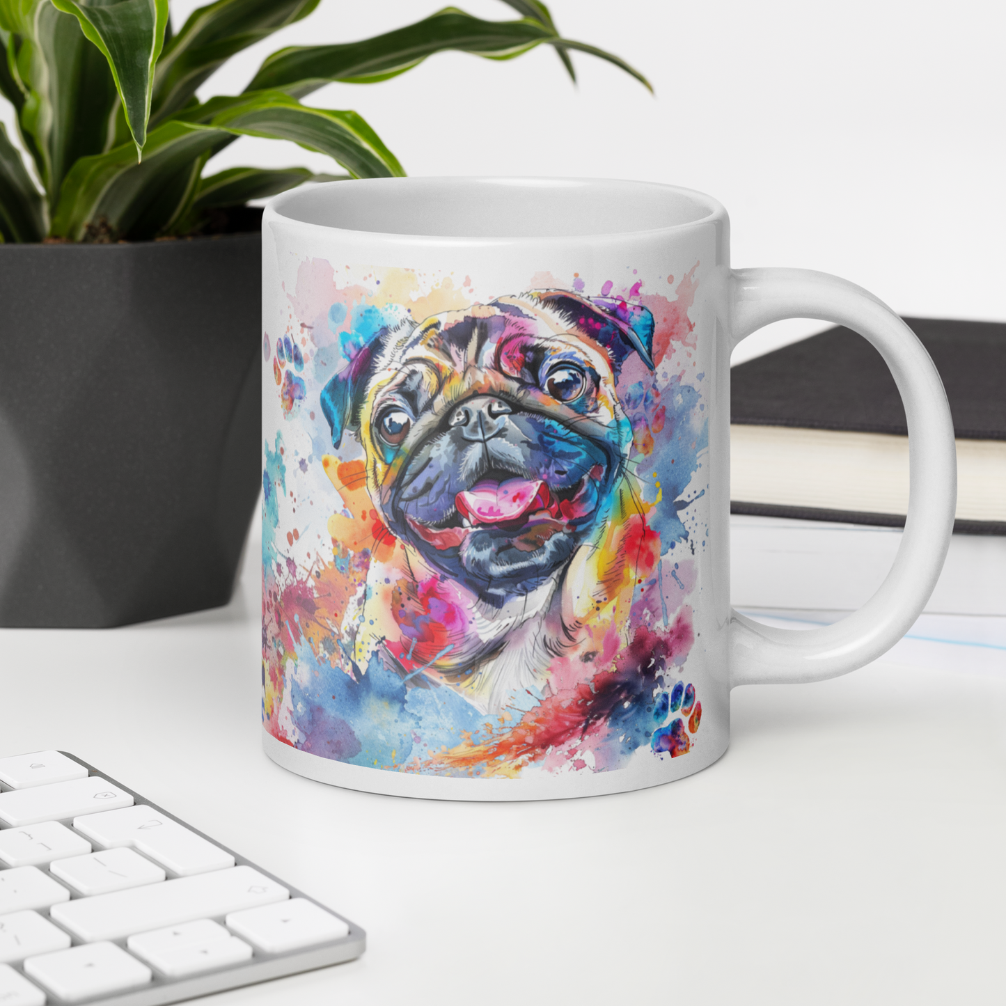 Doggone Proud Pug 20 oz Large Big Mug. A fun mug with a happy Pug dog surrounded by watercolor splashes, clouds, and paws. Mug is on a white desk with a plant book and keyboard. Great give for any dog lover or paw-rent.